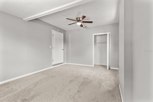 unfurnished bedroom with light colored carpet, a textured ceiling, and ceiling fan