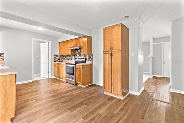 kitchen featuring stainless steel stove, a textured ceiling, and light wood-type flooring