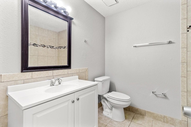 bathroom with vanity, a textured ceiling, toilet, and tile patterned floors