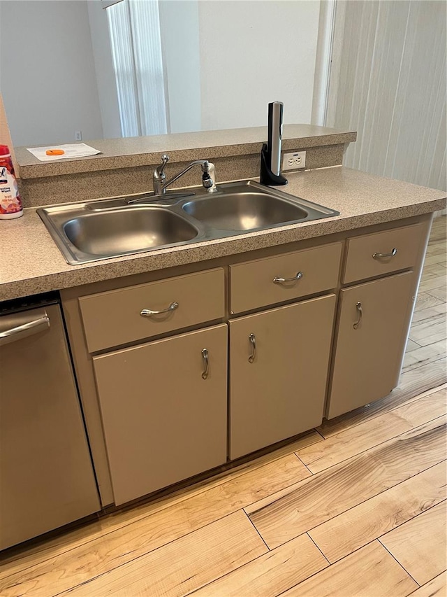 kitchen featuring light wood-type flooring, sink, and stainless steel dishwasher