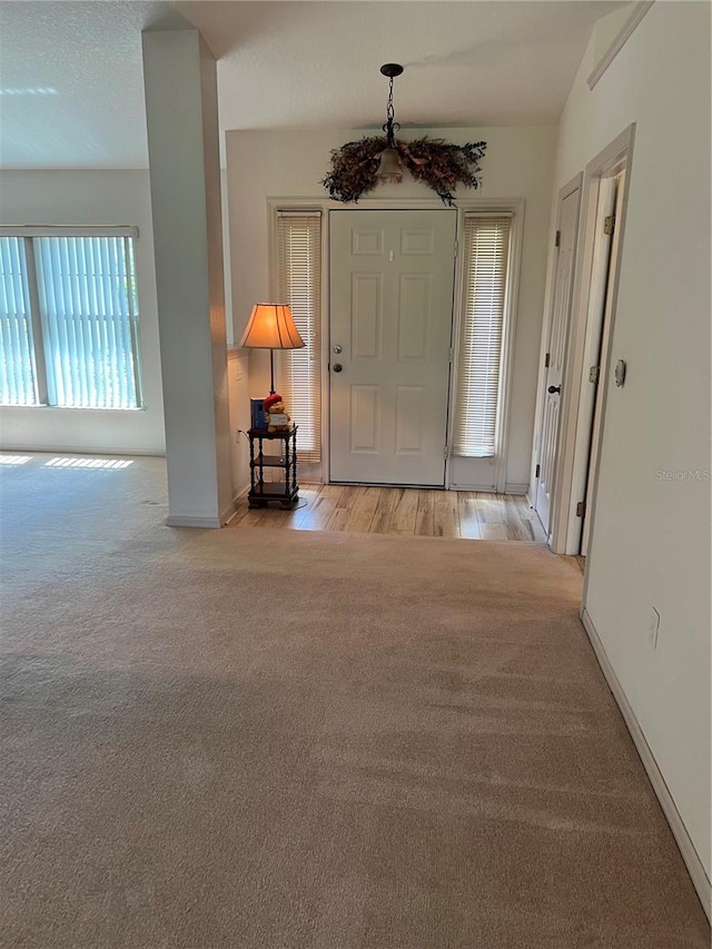 foyer entrance featuring light wood-type flooring and vaulted ceiling