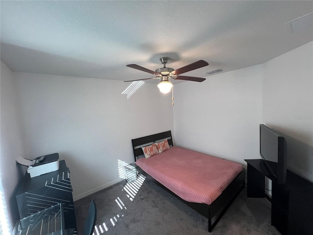 carpeted bedroom featuring ceiling fan and a textured ceiling