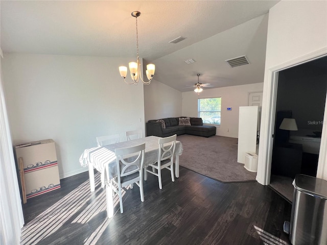 dining area with ceiling fan with notable chandelier, vaulted ceiling, and dark hardwood / wood-style flooring