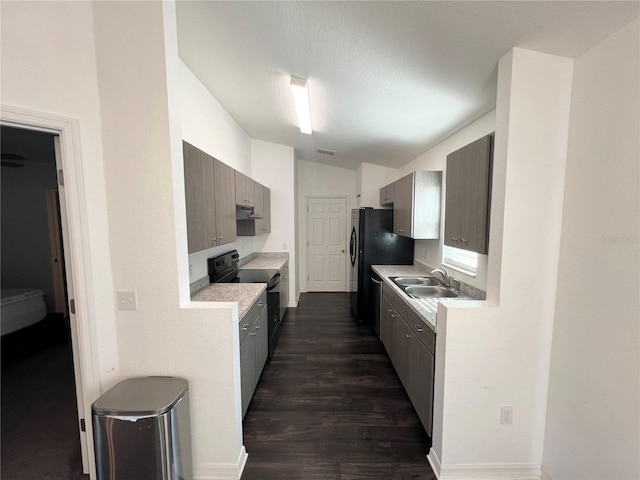 kitchen with lofted ceiling, sink, a textured ceiling, black appliances, and dark hardwood / wood-style floors