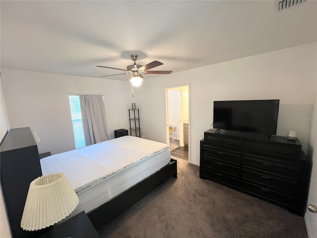 bedroom featuring dark carpet, ceiling fan, and ensuite bathroom