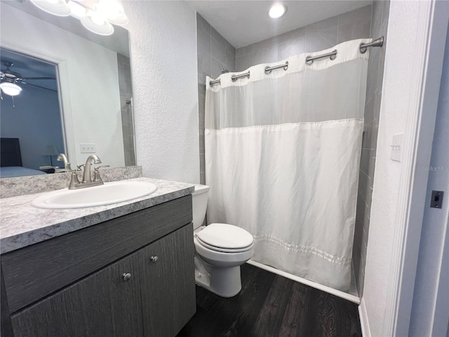 bathroom with hardwood / wood-style floors, curtained shower, vanity, and toilet