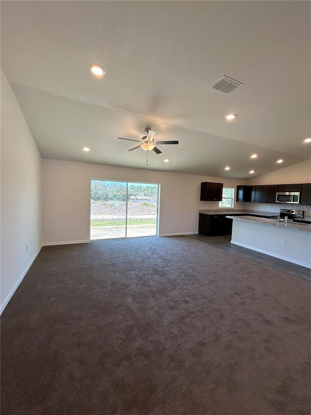 unfurnished living room featuring lofted ceiling, dark carpet, visible vents, and baseboards