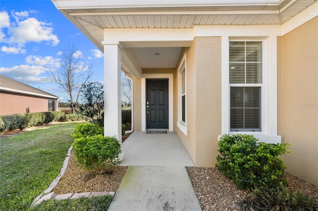 doorway to property featuring a lawn