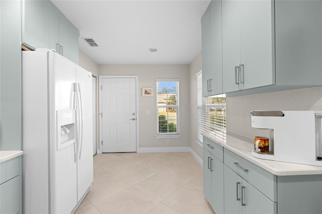 kitchen with white fridge with ice dispenser and light tile patterned floors