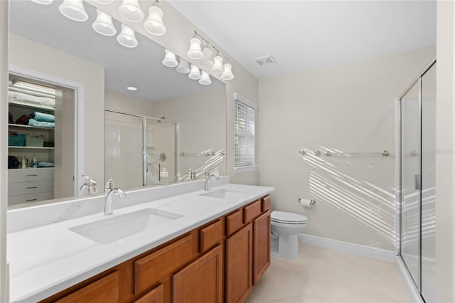 bathroom with vanity, tile patterned flooring, toilet, and an enclosed shower