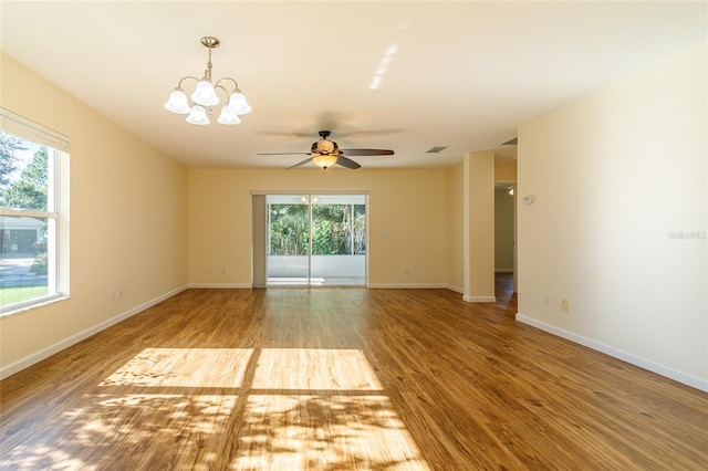 unfurnished room featuring ceiling fan with notable chandelier and hardwood / wood-style flooring