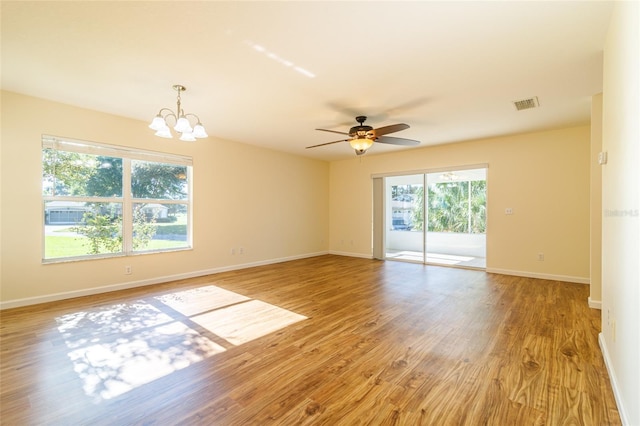 unfurnished room with ceiling fan with notable chandelier and light wood-type flooring