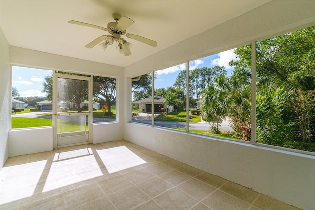 unfurnished sunroom with ceiling fan