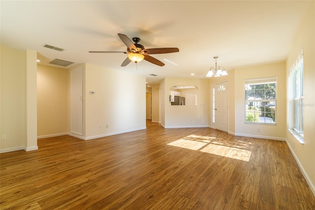 unfurnished living room featuring wood-type flooring and ceiling fan with notable chandelier