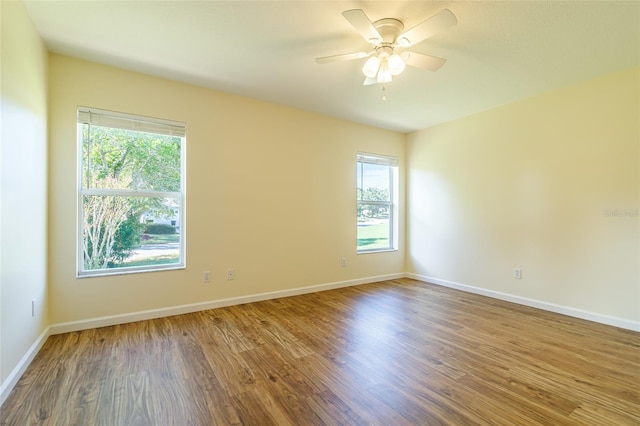 spare room featuring wood-type flooring, ceiling fan, and a wealth of natural light