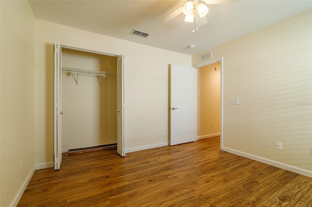 unfurnished bedroom featuring ceiling fan, a closet, and hardwood / wood-style floors