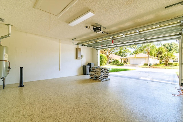 garage featuring water heater, a garage door opener, and electric panel