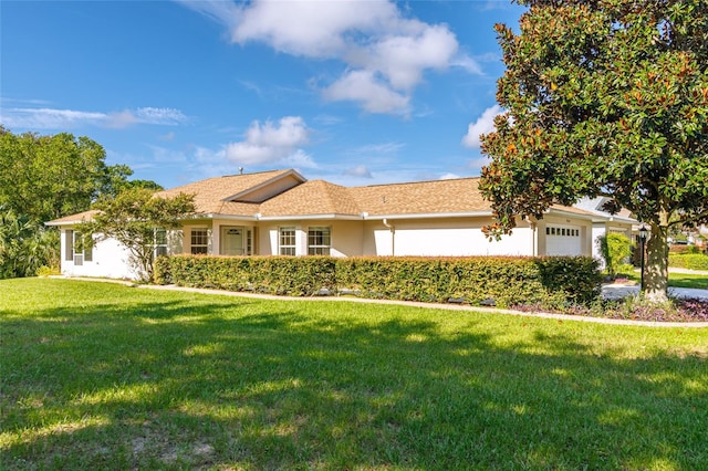 ranch-style home with a garage and a front lawn