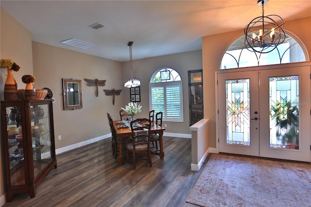 dining area featuring a textured ceiling, dark hardwood / wood-style flooring, french doors, and a notable chandelier