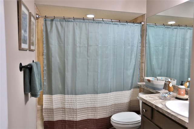 bathroom featuring a shower with shower curtain, vanity, and toilet