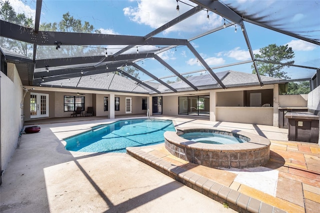 view of swimming pool featuring glass enclosure, an in ground hot tub, and a patio