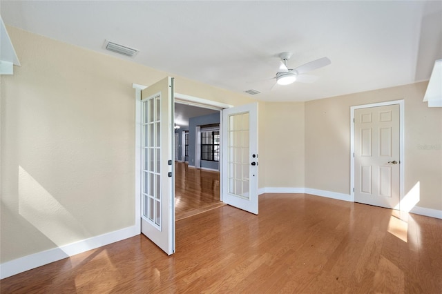 unfurnished room with ceiling fan, light hardwood / wood-style flooring, and french doors