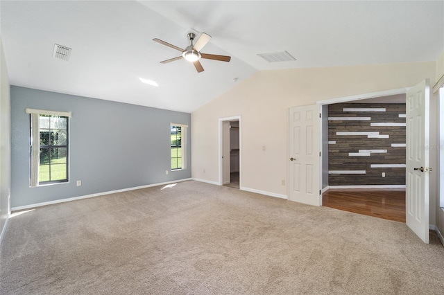 unfurnished bedroom with ceiling fan, lofted ceiling, carpet flooring, a walk in closet, and a closet