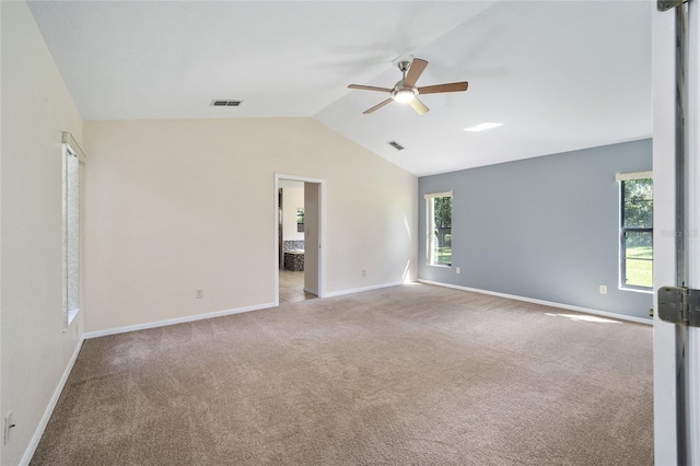 carpeted spare room featuring vaulted ceiling and ceiling fan