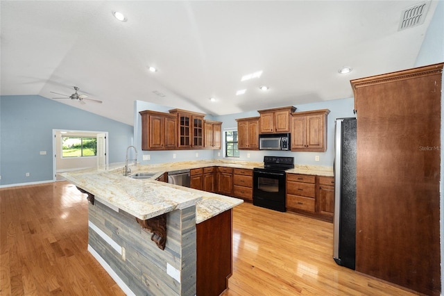 kitchen with lofted ceiling, ceiling fan, kitchen peninsula, appliances with stainless steel finishes, and a breakfast bar area