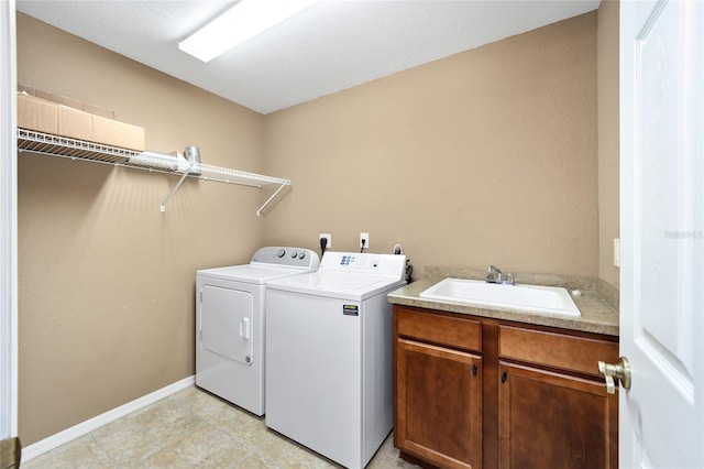 laundry area featuring cabinets, separate washer and dryer, and sink