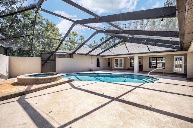 view of pool featuring a lanai, french doors, a patio area, and an in ground hot tub