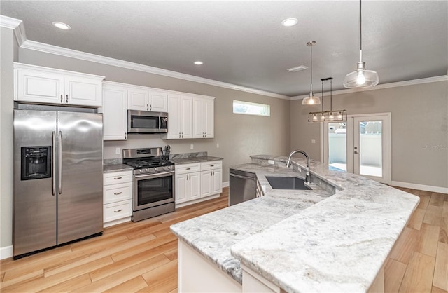 kitchen with light wood-type flooring, sink, white cabinetry, stainless steel appliances, and a center island with sink