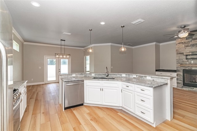 kitchen featuring pendant lighting, sink, white cabinetry, appliances with stainless steel finishes, and light hardwood / wood-style floors