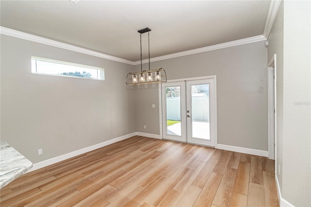 empty room featuring light wood-type flooring, french doors, and crown molding