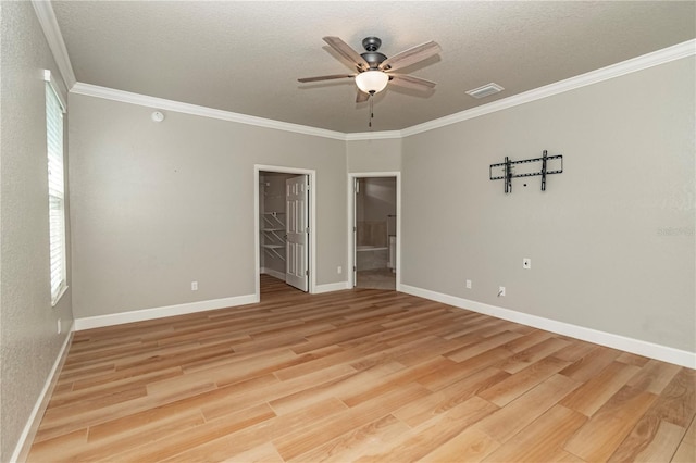 unfurnished bedroom featuring wood-type flooring, a textured ceiling, and a walk in closet