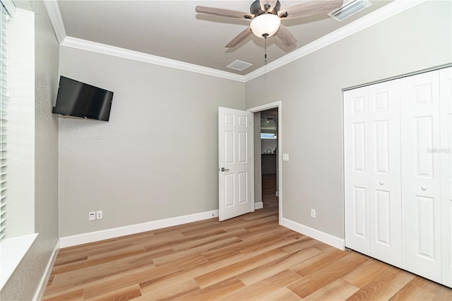 unfurnished bedroom featuring crown molding, ceiling fan, a closet, and hardwood / wood-style flooring