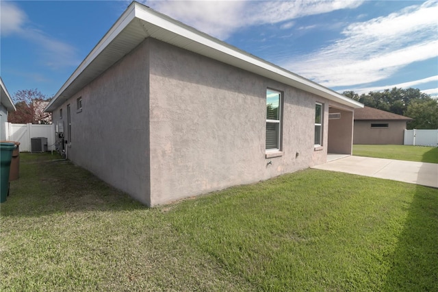 view of home's exterior with a yard, a patio, and central AC