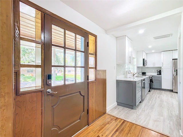 doorway to outside featuring light hardwood / wood-style flooring and sink