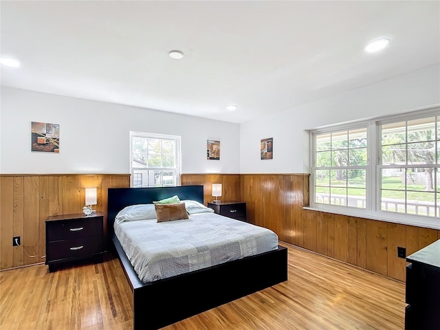 bedroom featuring wooden walls and light hardwood / wood-style flooring