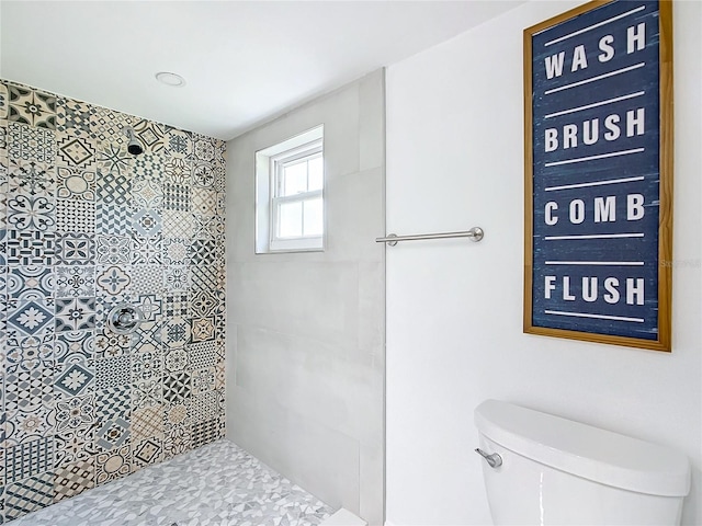 bathroom featuring tiled shower and toilet