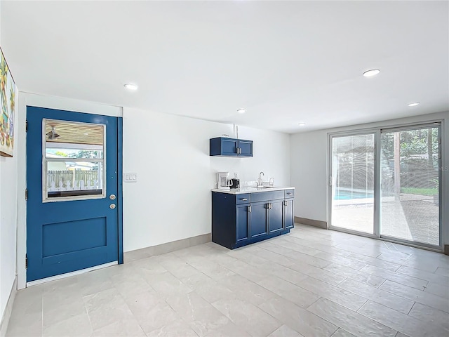 kitchen with blue cabinetry, plenty of natural light, and sink