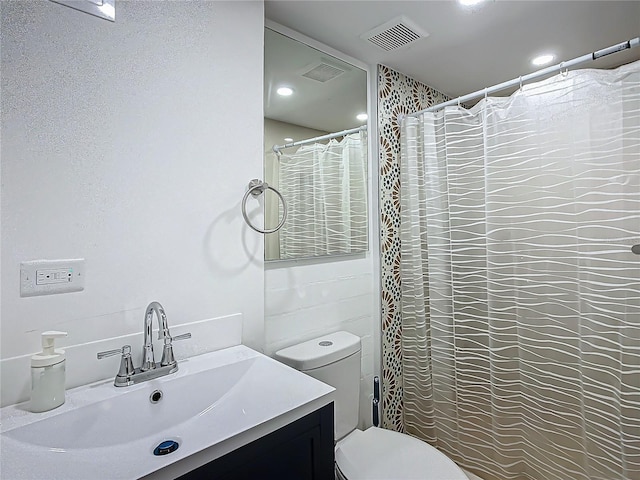 bathroom featuring vanity, toilet, and a shower with shower curtain