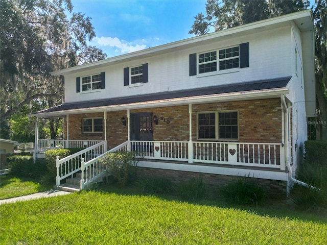 view of front of house with a front yard and covered porch