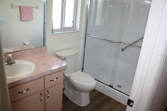 bathroom featuring walk in shower, vanity, toilet, and hardwood / wood-style flooring