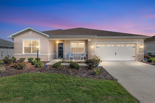 ranch-style house featuring a garage, a porch, and a lawn