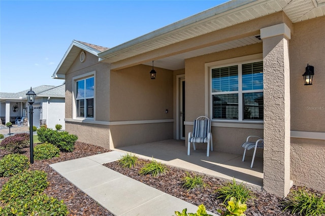 view of exterior entry with a patio area