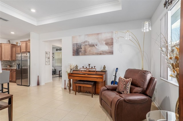 sitting room featuring a raised ceiling and ornamental molding