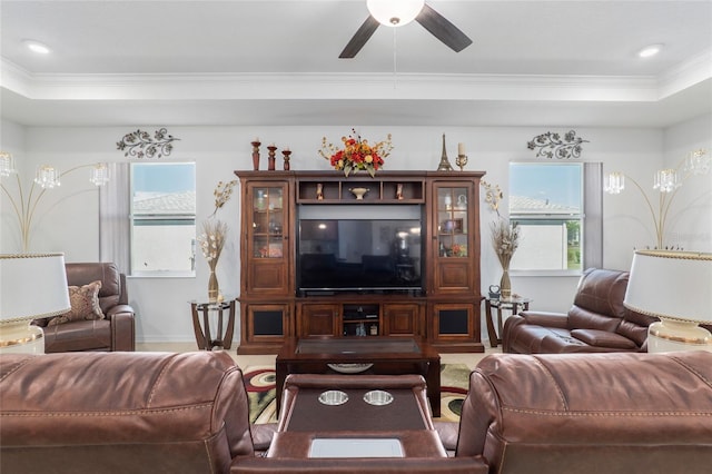 living room with crown molding, ceiling fan, a healthy amount of sunlight, and a tray ceiling