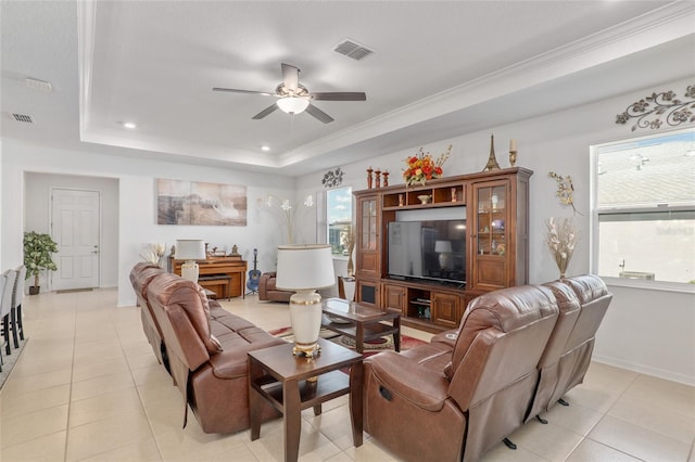 living room with ornamental molding, light tile patterned floors, ceiling fan, and a tray ceiling