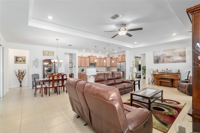 tiled living room featuring ceiling fan with notable chandelier, a raised ceiling, and crown molding